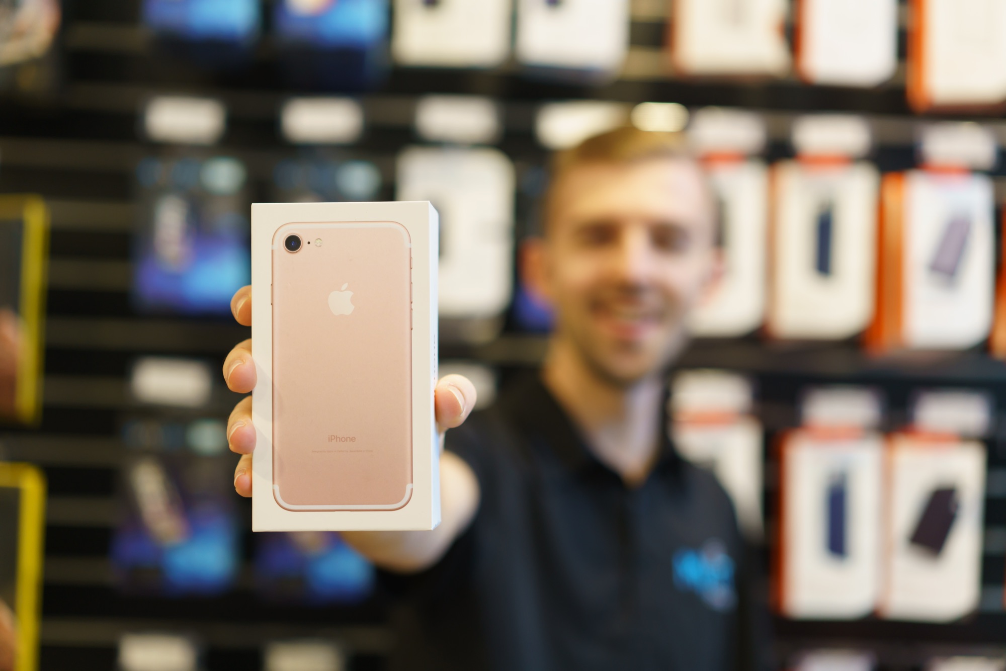 My IT Shop team member holding up a boxed iPhone